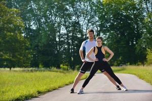 Couple doing stretching exercise  after jogging photo