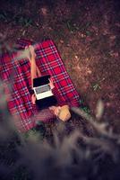 top view of man using a laptop computer under the tree photo