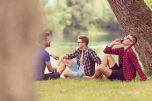 men sitting on the bank of the river photo