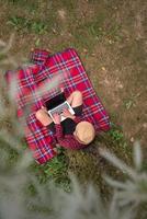 top view of man using a laptop computer under the tree photo