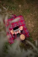 top view of man using a laptop computer under the tree photo