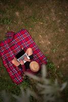 top view of man using a laptop computer under the tree photo