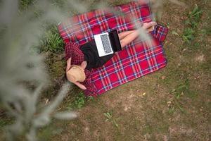top view of man using a laptop computer under the tree photo