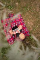 top view of man using a laptop computer under the tree photo