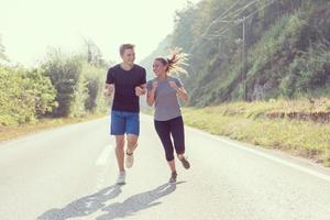 pareja joven trotando a lo largo de un camino rural foto