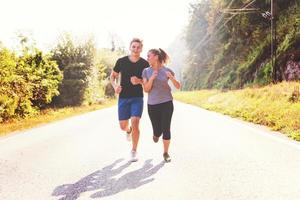 young couple jogging along a country road photo