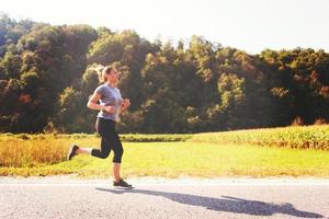 mujer corriendo por un camino rural foto