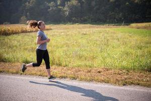 woman jogging along a country road photo