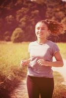 mujer corriendo por un camino rural foto