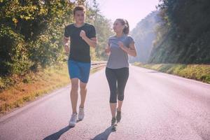 young couple jogging along a country road photo