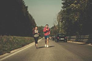 pareja joven trotando a lo largo de un camino rural foto