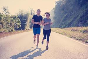 young couple jogging along a country road photo