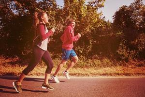 young couple jogging along a country road photo