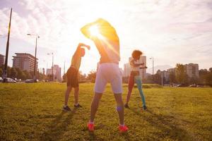 multiethnic group of people stretching in city park photo