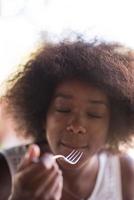 a young African American woman eating pasta photo