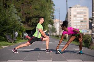 jogging couple warming up and stretching in the city photo