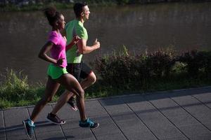 young smiling multiethnic couple jogging in the city photo