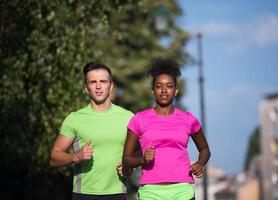 young smiling multiethnic couple jogging in the city photo