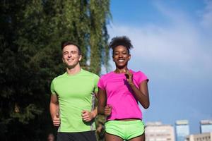 young smiling multiethnic couple jogging in the city photo