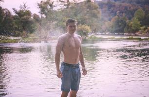 man with a bare torso splashing water photo