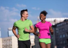 young smiling multiethnic couple jogging in the city photo