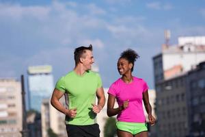 young smiling multiethnic couple jogging in the city photo