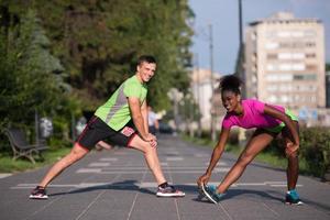 jogging couple warming up and stretching in the city photo