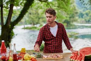 man putting spices on raw meat for barbecue photo