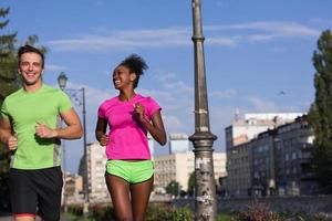 young smiling multiethnic couple jogging in the city photo