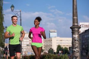 young smiling multiethnic couple jogging in the city photo