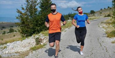 couple running in nature wearing mask photo