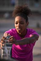 mujer afroamericana haciendo calentamiento y estiramiento foto