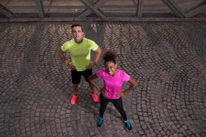 portrait of a young multiethnic couple jogging in the city photo