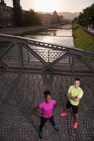 portrait of a young multiethnic couple jogging in the city photo