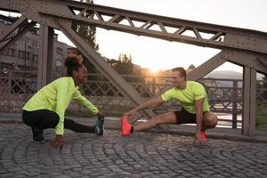 pareja de jogging calentándose y estirándose en la ciudad foto