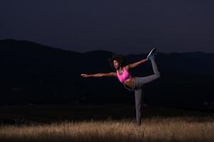 mujer negra haciendo yoga en la naturaleza foto