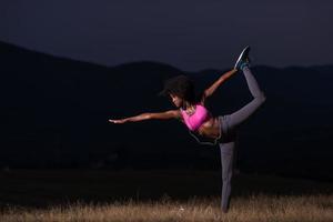 mujer negra haciendo yoga en la naturaleza foto