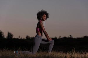 black woman is doing stretching exercise relaxing and warm up photo