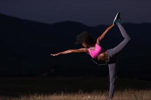 mujer negra haciendo yoga en la naturaleza foto