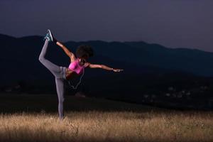 mujer negra haciendo yoga en la naturaleza foto