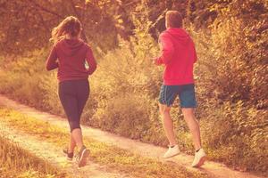 young couple jogging along a country road photo