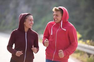 young couple jogging along a country road photo