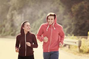 young couple jogging along a country road photo