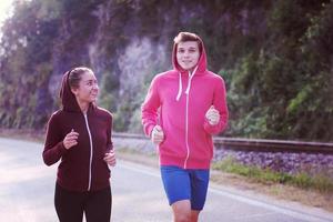 young couple jogging along a country road photo