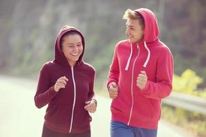 young couple jogging along a country road photo