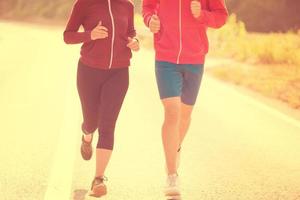 young couple jogging along a country road photo