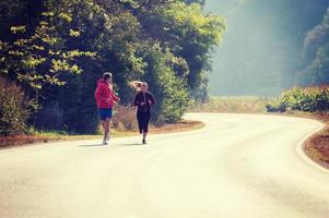 young couple jogging along a country road photo