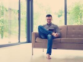 man on sofa using tablet computer photo
