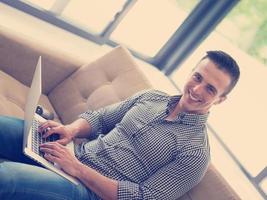 Man using laptop in living room photo