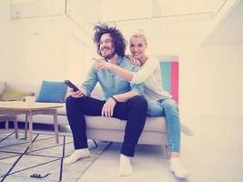 Young couple on the sofa watching television photo